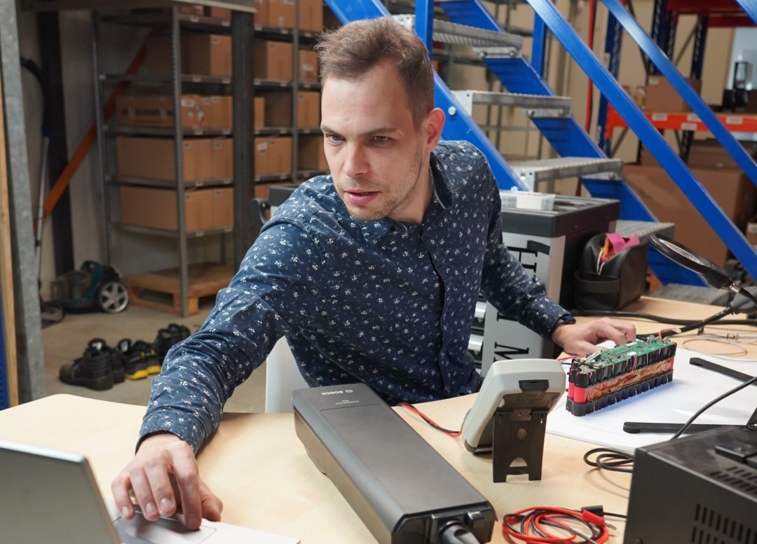 Op deze afbeelding zie je de elektrotechnisch manger van e-bikeaccu.nl zorgvuldig testen uitvoeren voor de nieuwe fietsaccu's